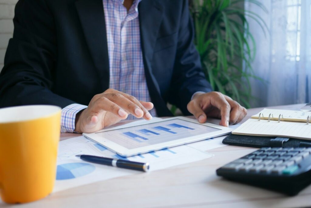 Employee reviewing a 401(k) statement beside a calculator and workplace benefits documents.