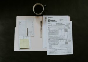 An employee reviews workplace benefits forms and payroll deduction details at a kitchen table.