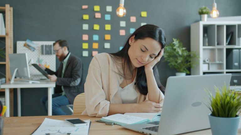 Employee reviews a PTO policy beside a calendar marked with vacation and sick days.
